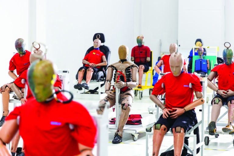 Inside Geely’s $250 million Safety Center in Hangzhou Rows of crash test dummies in red T-shirts, some seated on test rigs and vehicle seats, others fitted with exposed mechanical torsos and jointed limbs, lined up inside Geely's Safety Center testing facility
