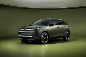 Volkswagen unveils ID. Cross electric SUV Front three-quarter studio shot of the olive-green Volkswagen ID. Cross electric SUV, showing its illuminated front light bar, badge-free grille and large alloy wheels against a green backdrop