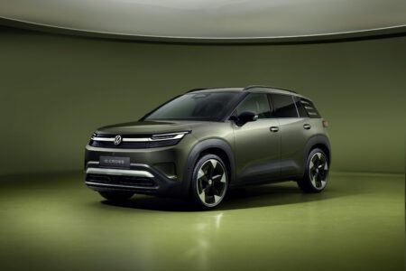 Volkswagen unveils ID. Cross electric SUV Front three-quarter studio shot of the olive-green Volkswagen ID. Cross electric SUV, showing its illuminated front light bar, badge-free grille and large alloy wheels against a green backdrop